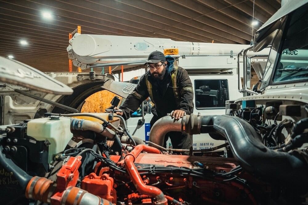 Mach 6 technician inspecting turbo and exhaust plumbing in an engine bay