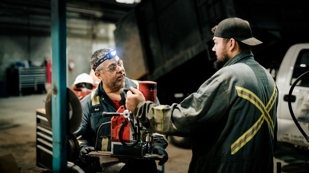 Mach 6 technicians reviewing a job together on the shop floor