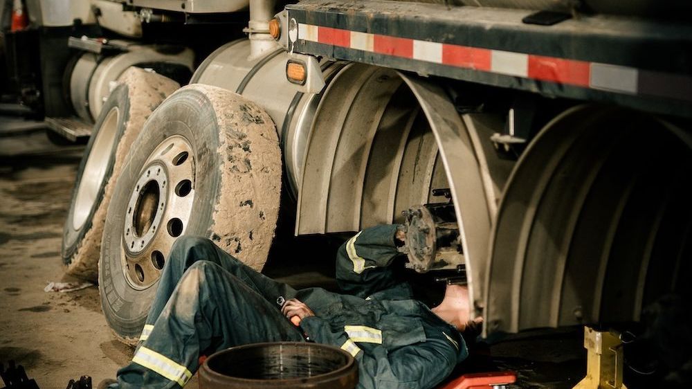 Mach 6 technician working on a heavy-duty axle and suspension assembly